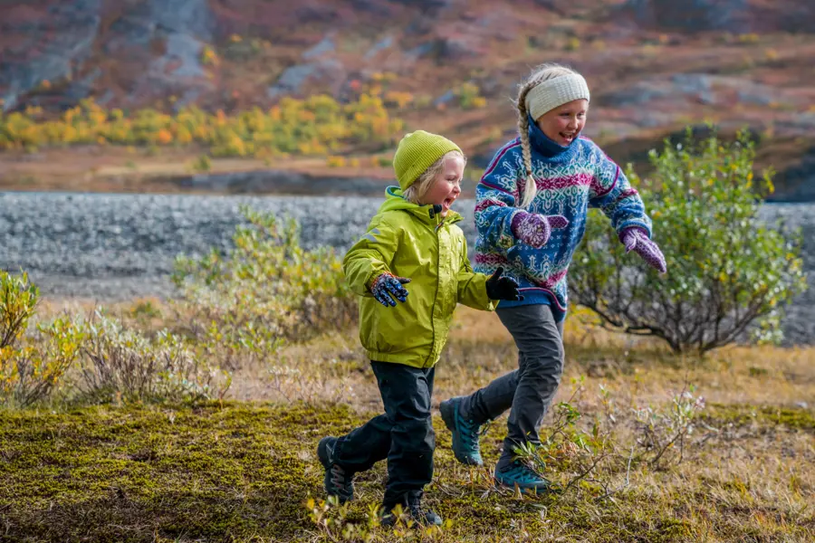 To glade barn løper ute i naturen